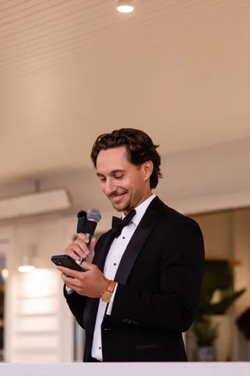 Jack in a tuxedo speaking into a microphone