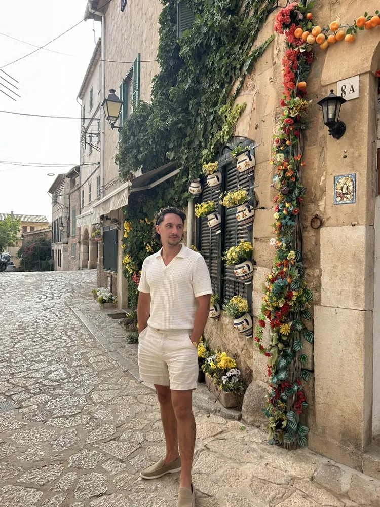 Jack on a cobblestone street lined with flowers